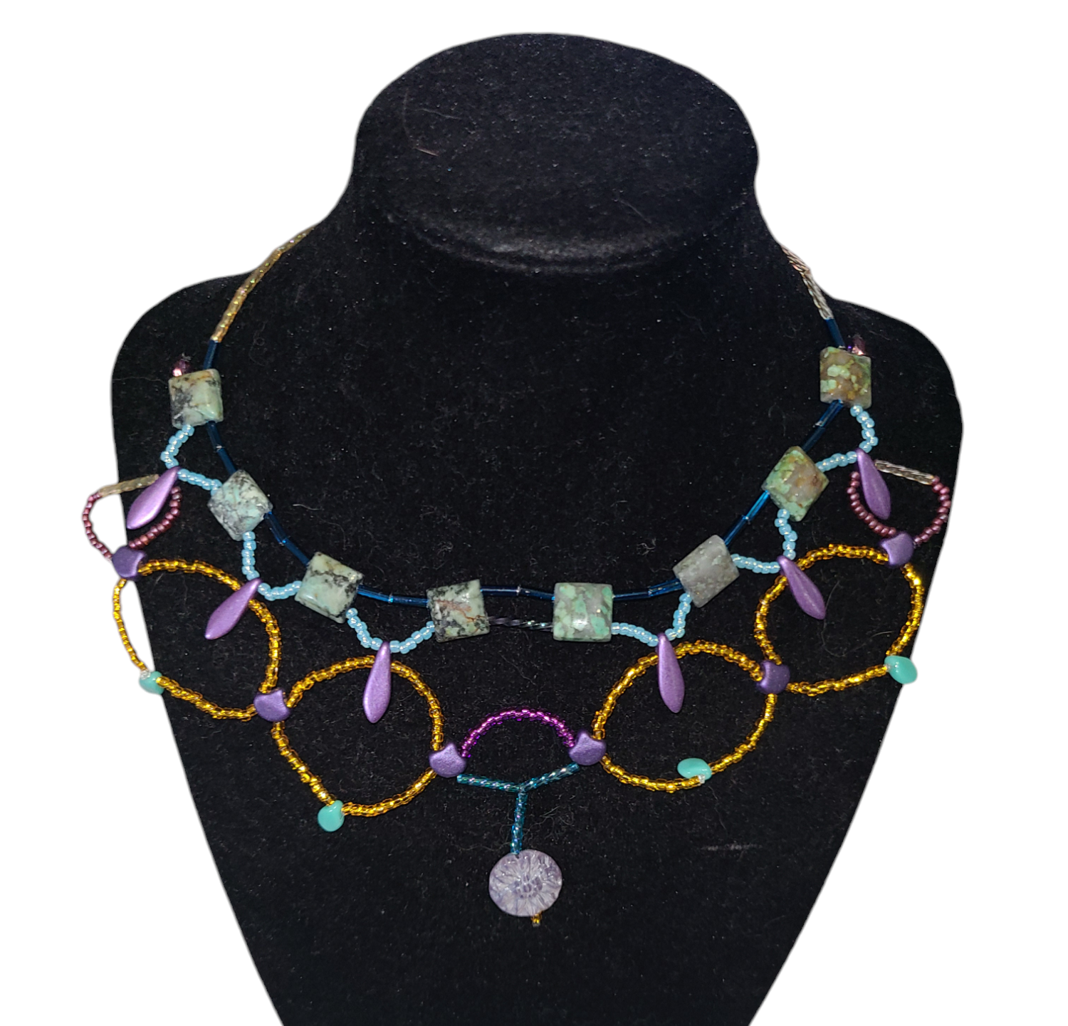 African turquoise necklace on necklace form, featuring purple and teal glass beads.