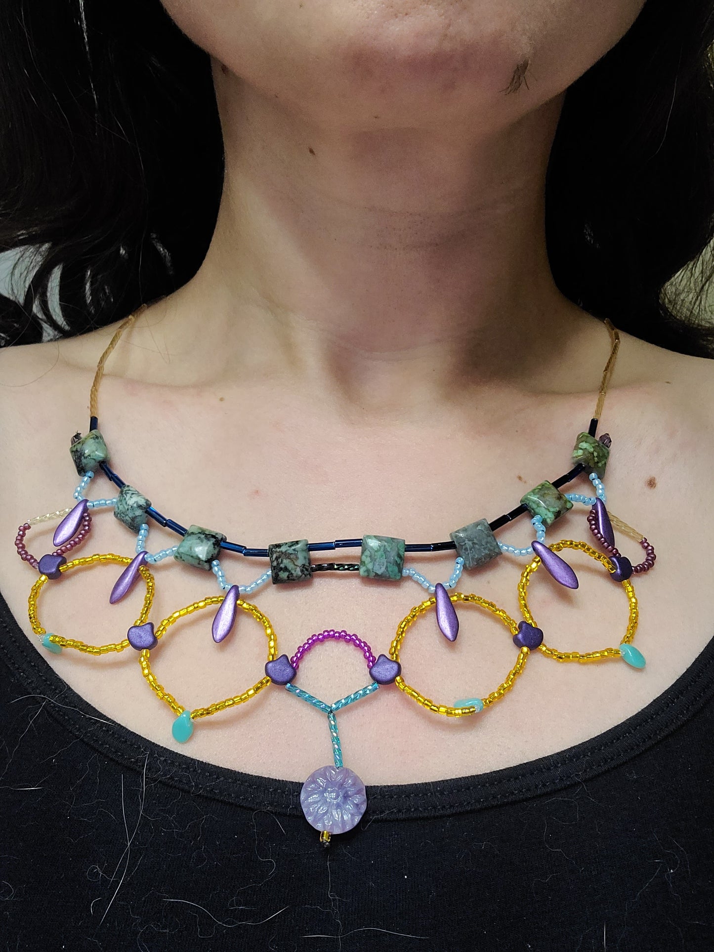 A model wearing the African turquoise Cleopatra necklace with a black tank top.