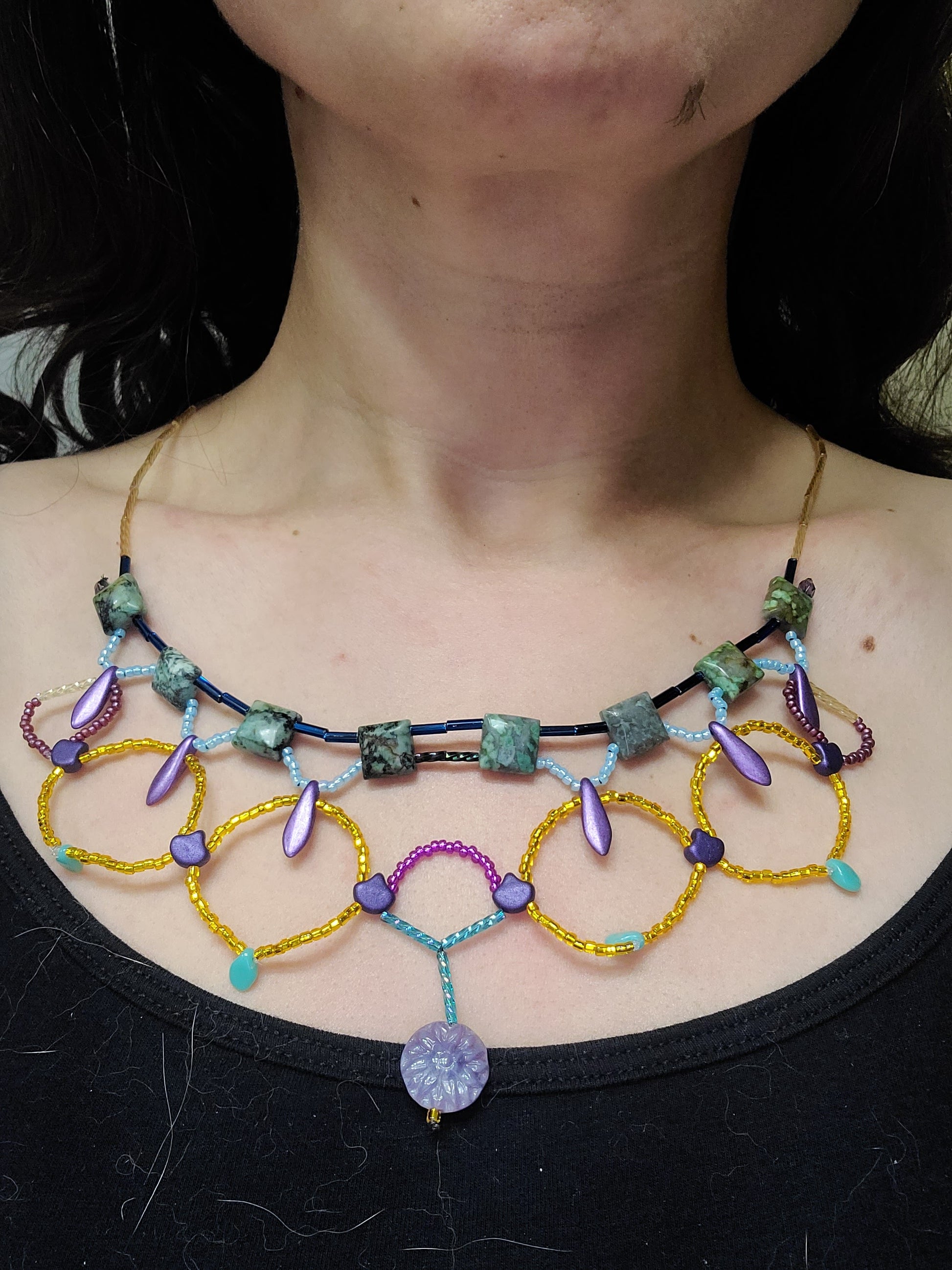 A model wearing the African turquoise Cleopatra necklace with a black tank top.