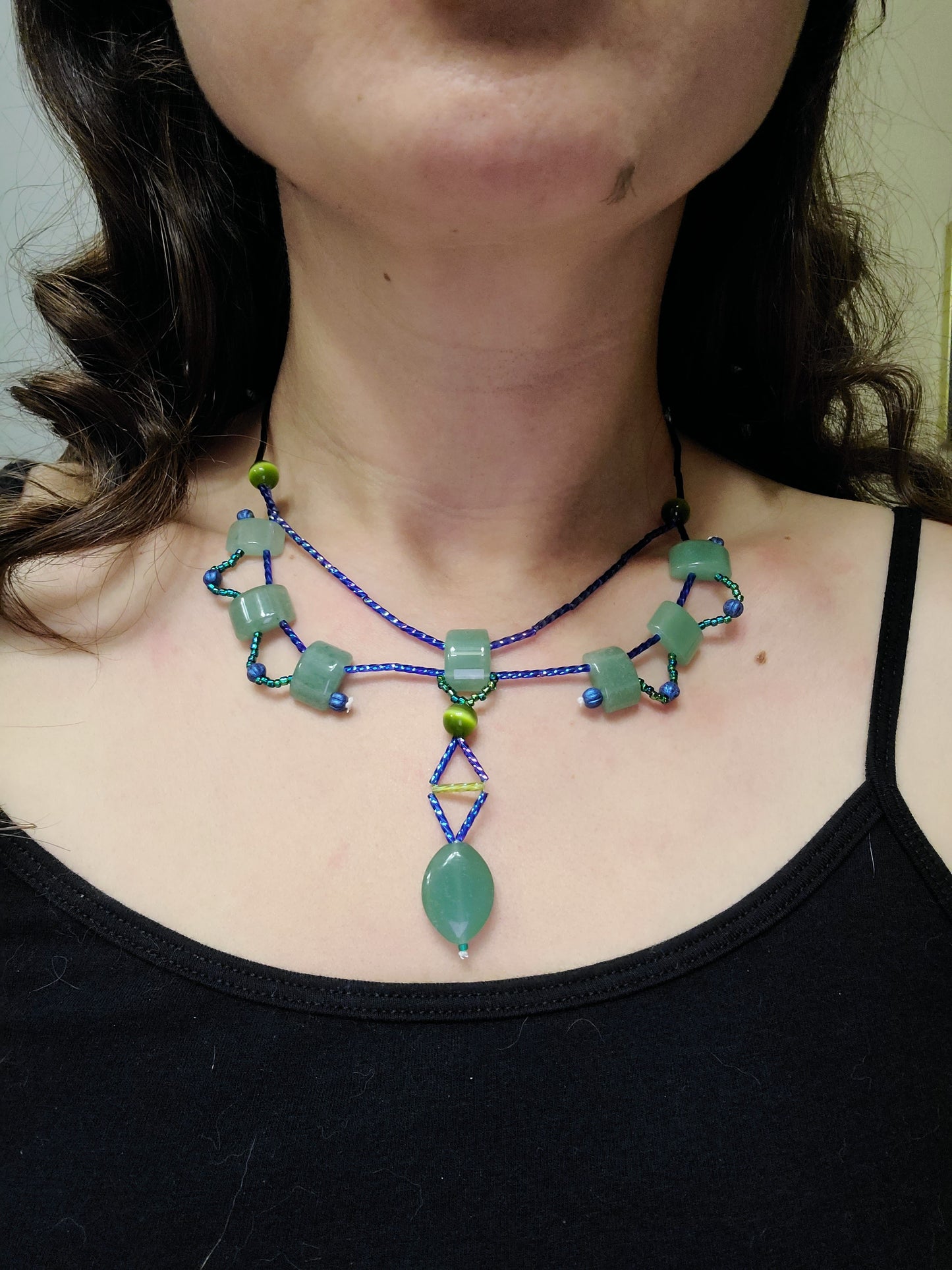 A model wearing an aventurine statement necklace featuring green and blue tones.
