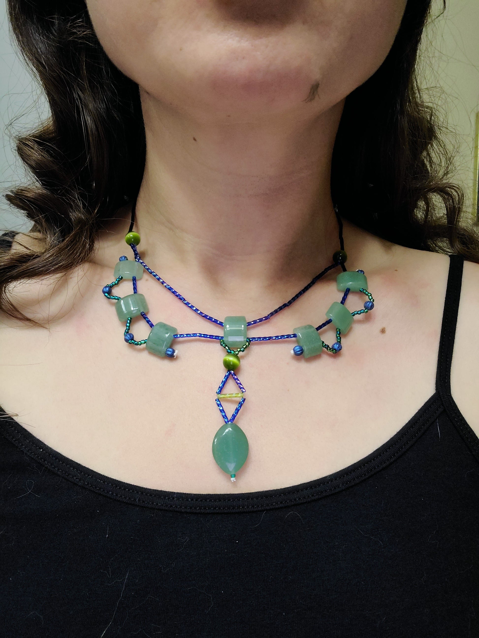 A model wearing an aventurine statement necklace featuring green and blue tones.