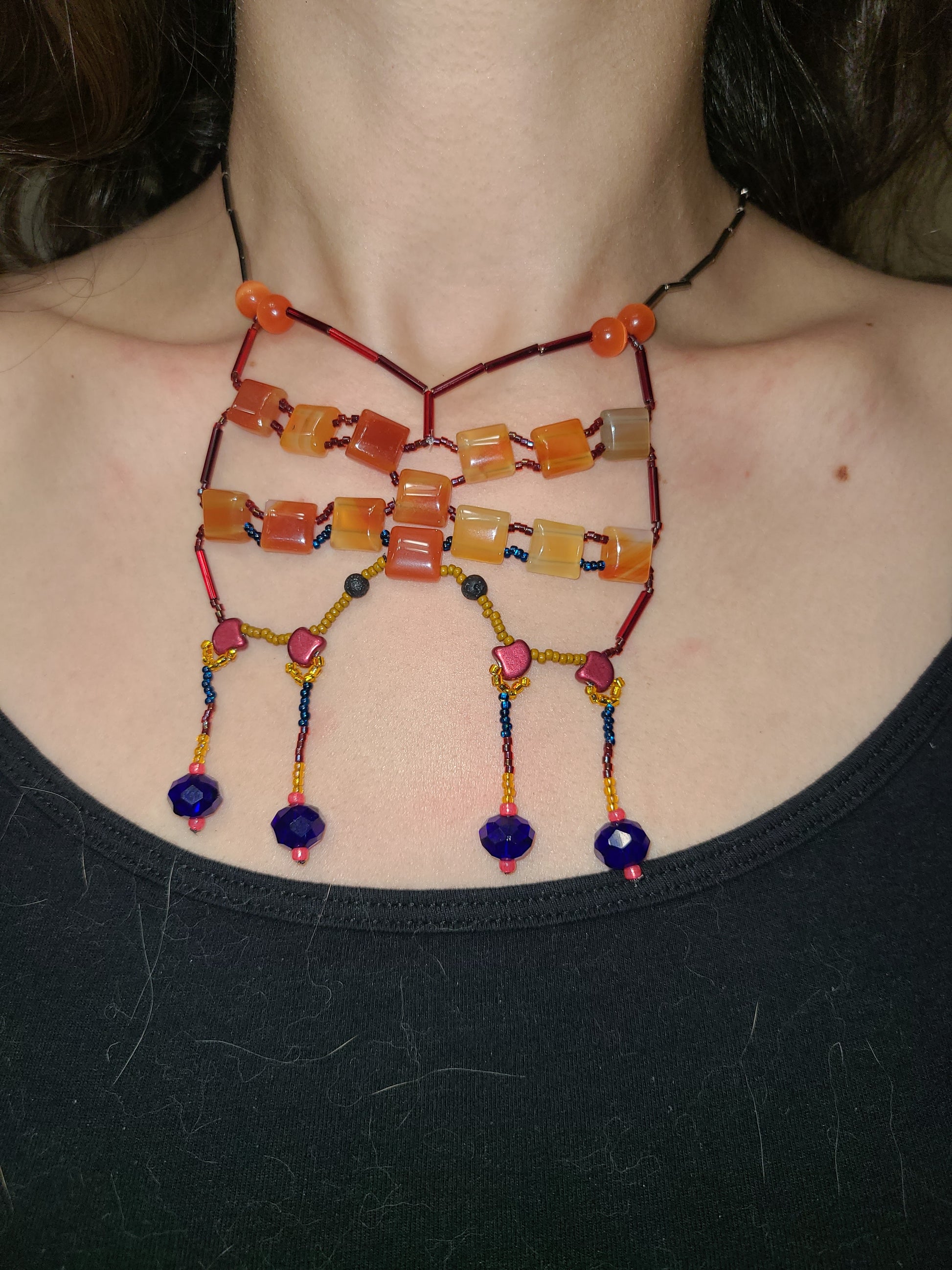 Woman wearing carnelian starlit sands statement necklace.