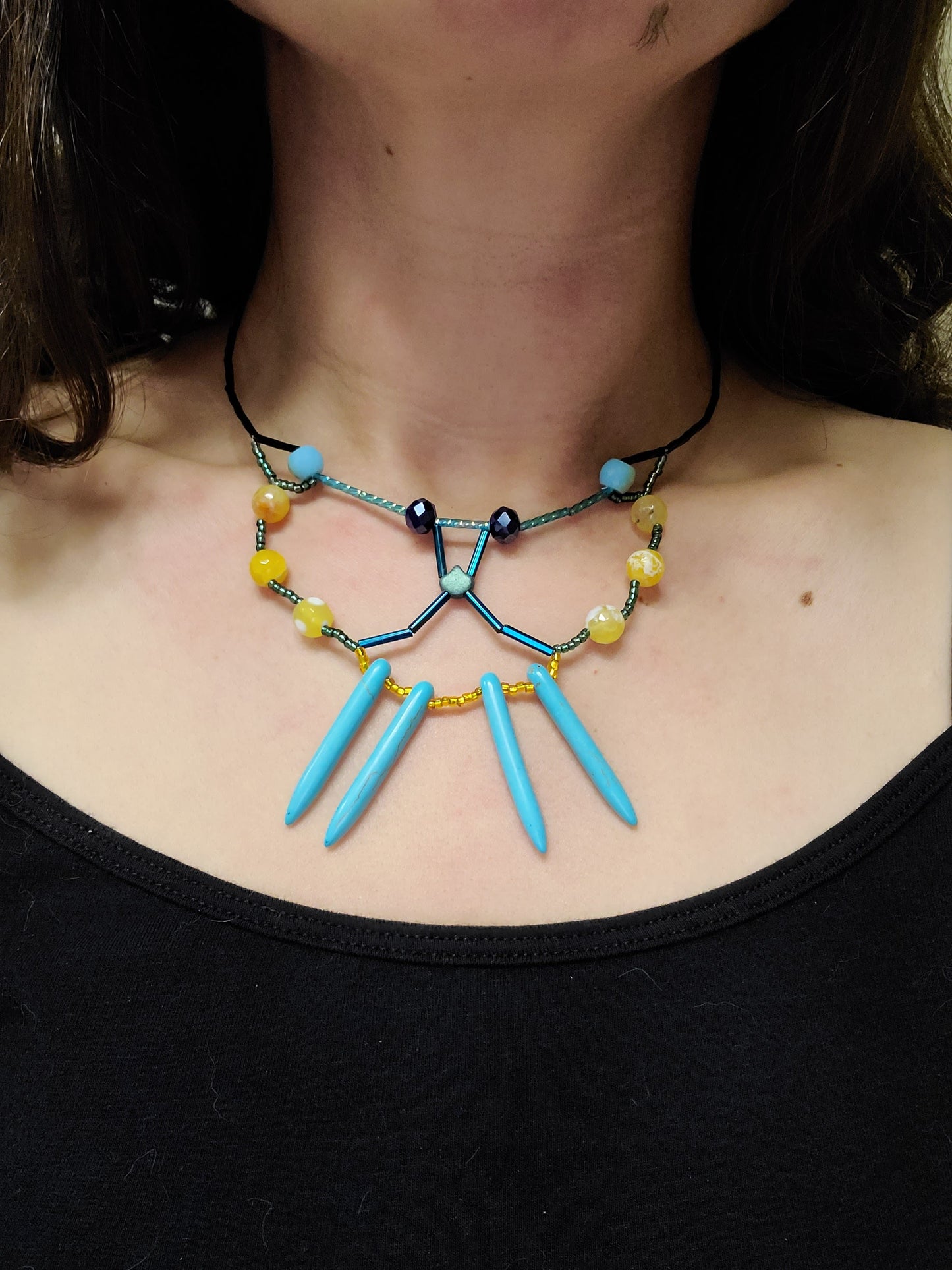 Woman wearing teal and gold butterfly necklace