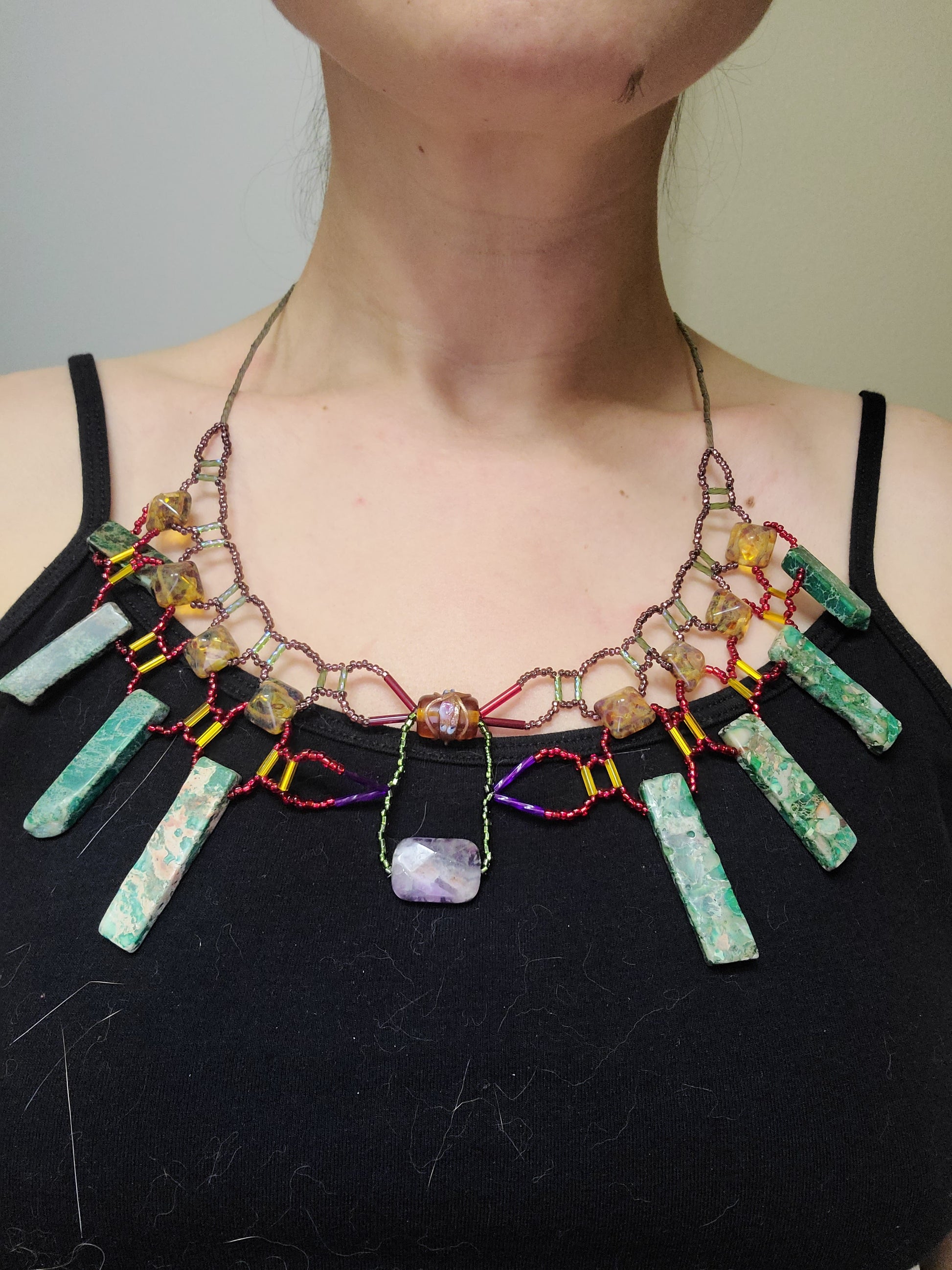 Woman wearing bold collar necklace with green jasper