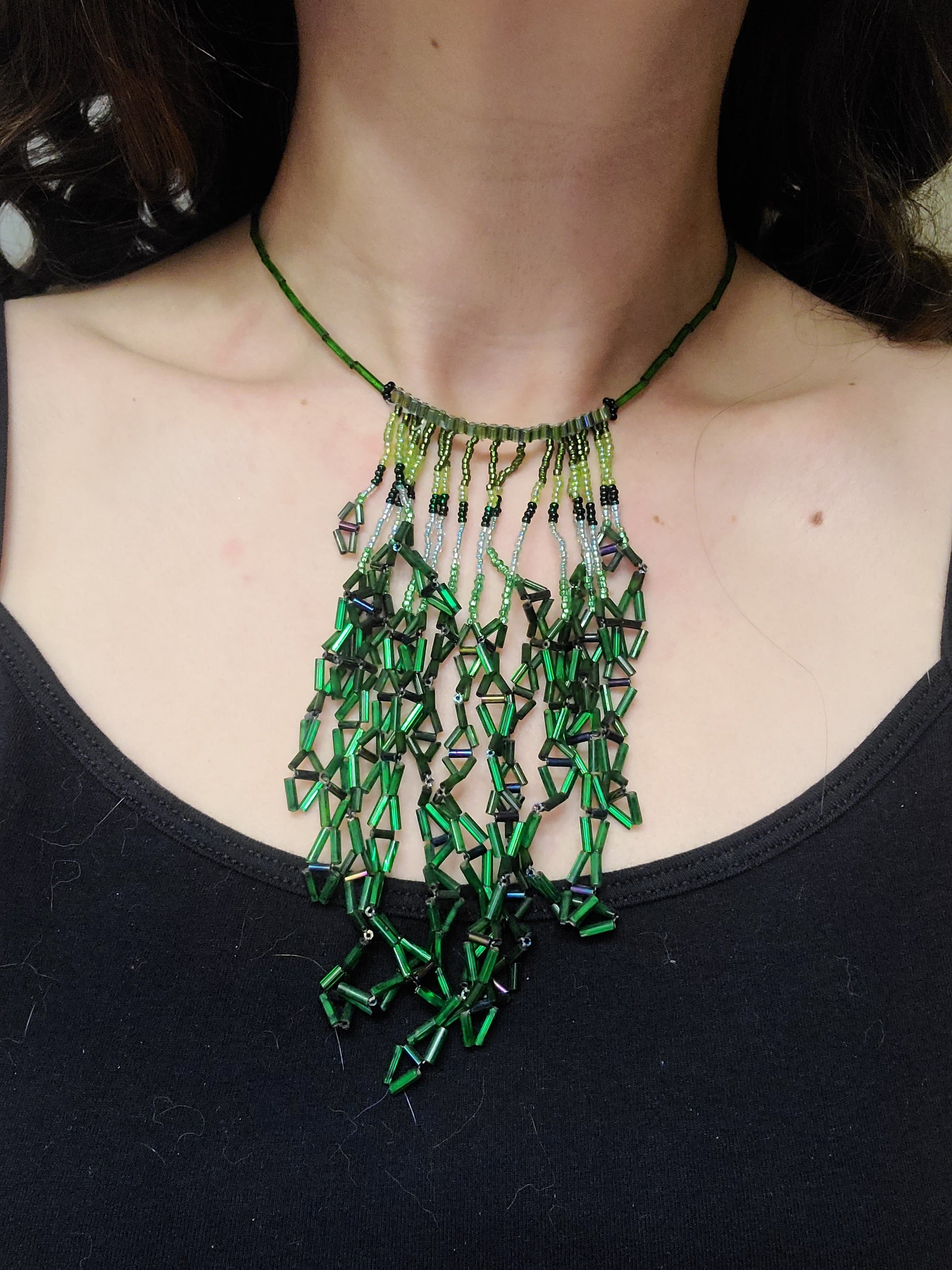 Woman wearing green diamond fringe necklace
