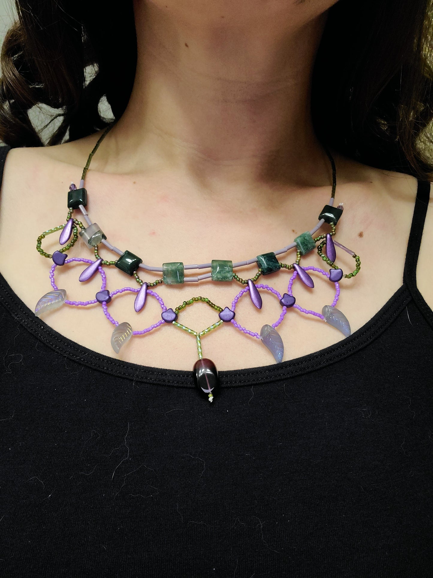 Woman wearing green and purple moss agate statement necklace