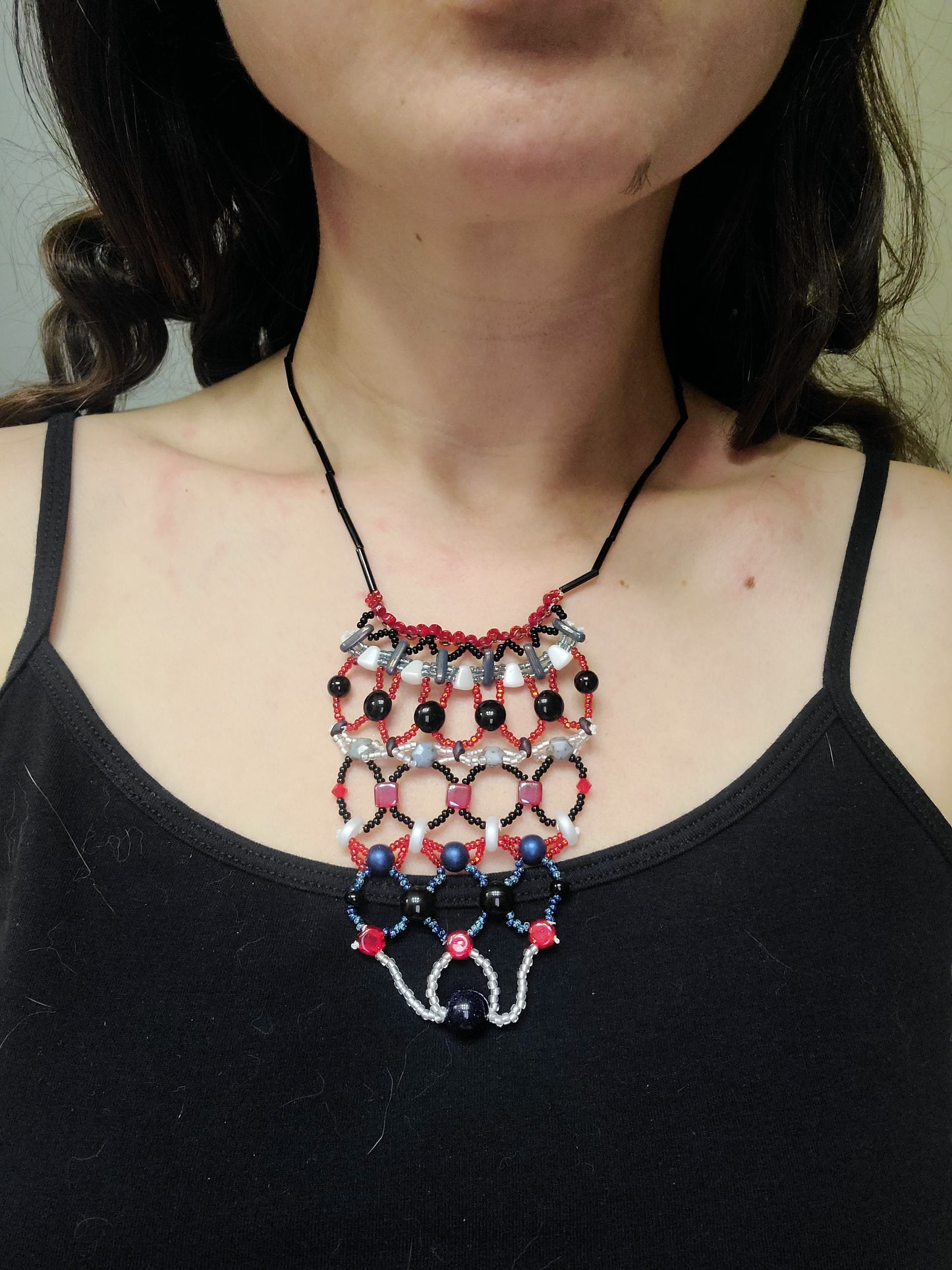 Dark-haired woman wearing red, white and blue winter tapestry necklace