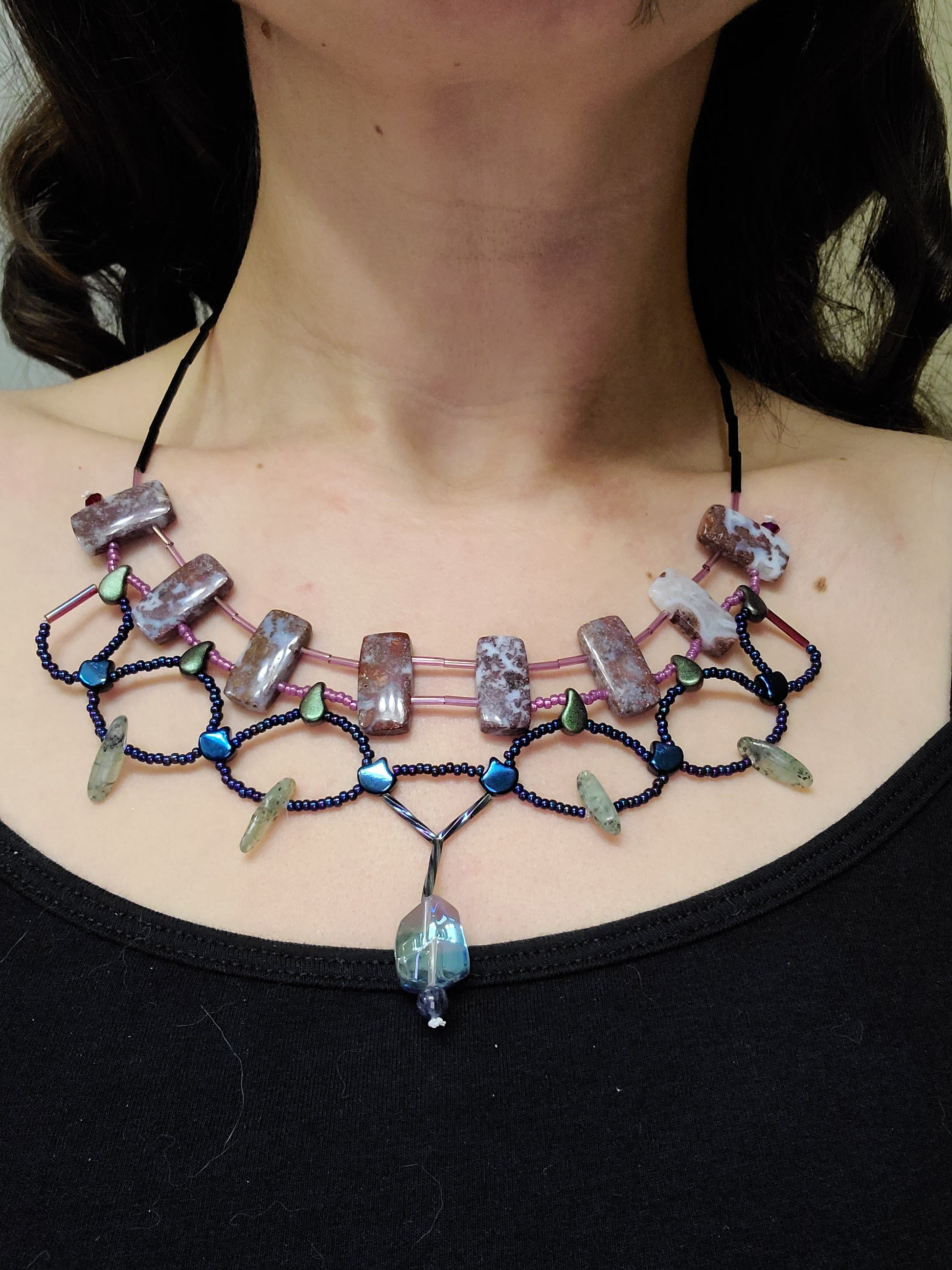 Woman wearing red lightning agate statement necklace