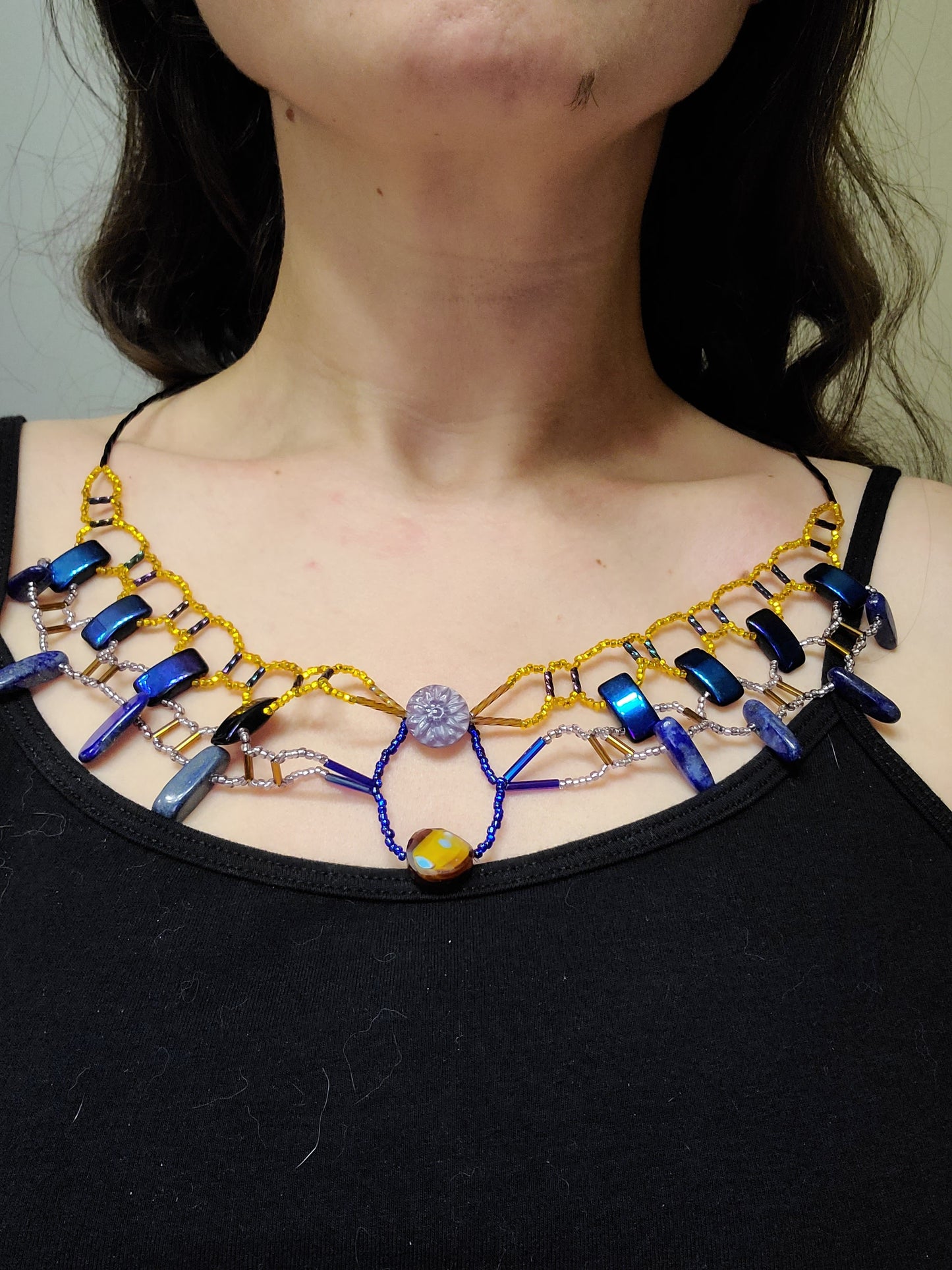 Dark-haired woman wearing royal blue and gold lapis collar necklace