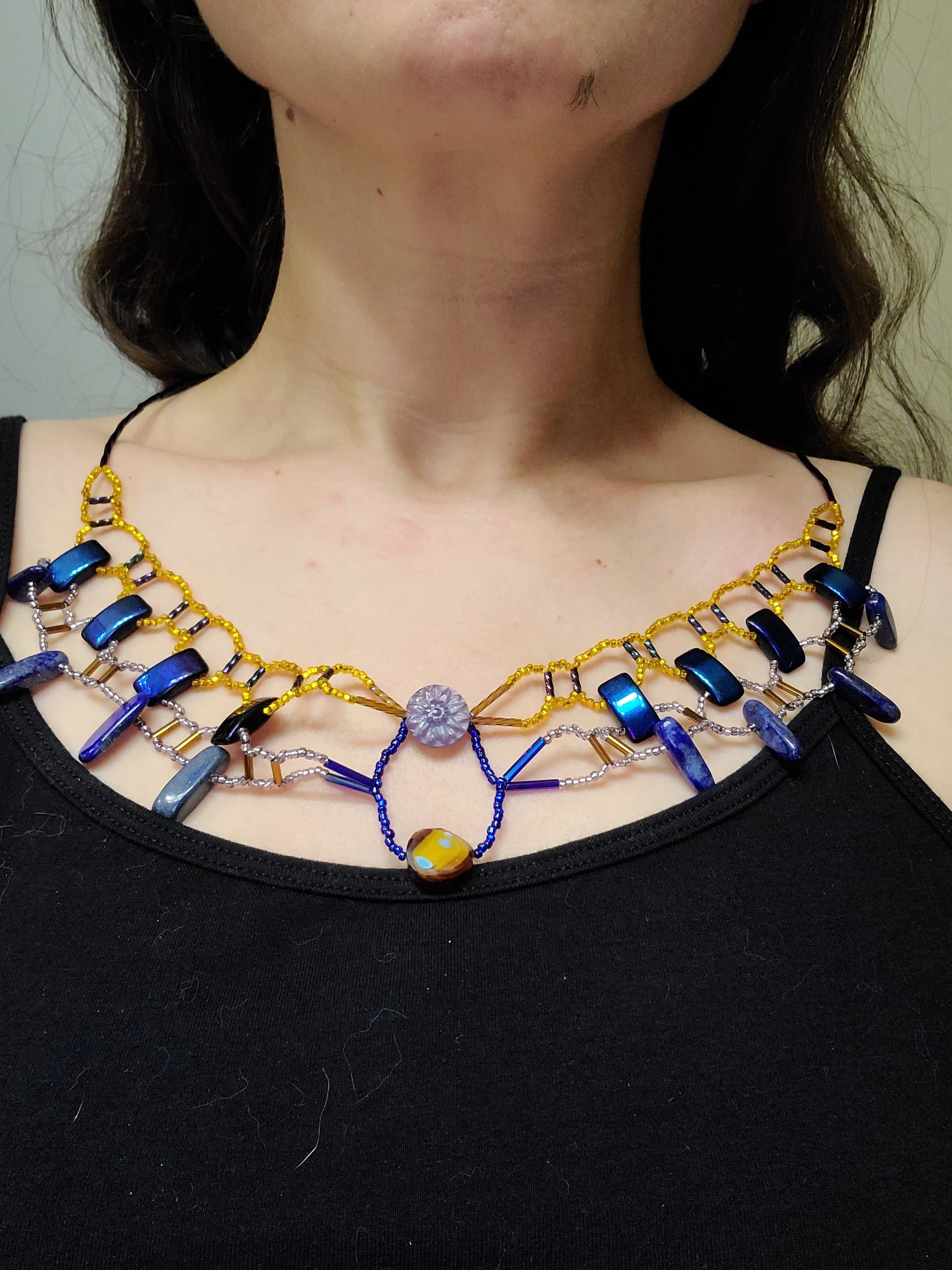 Dark-haired woman wearing royal blue and gold lapis collar necklace