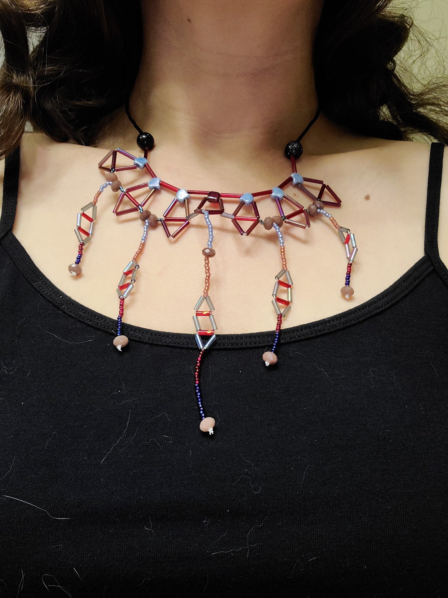 Woman wearing icy blue and red ruby necklace