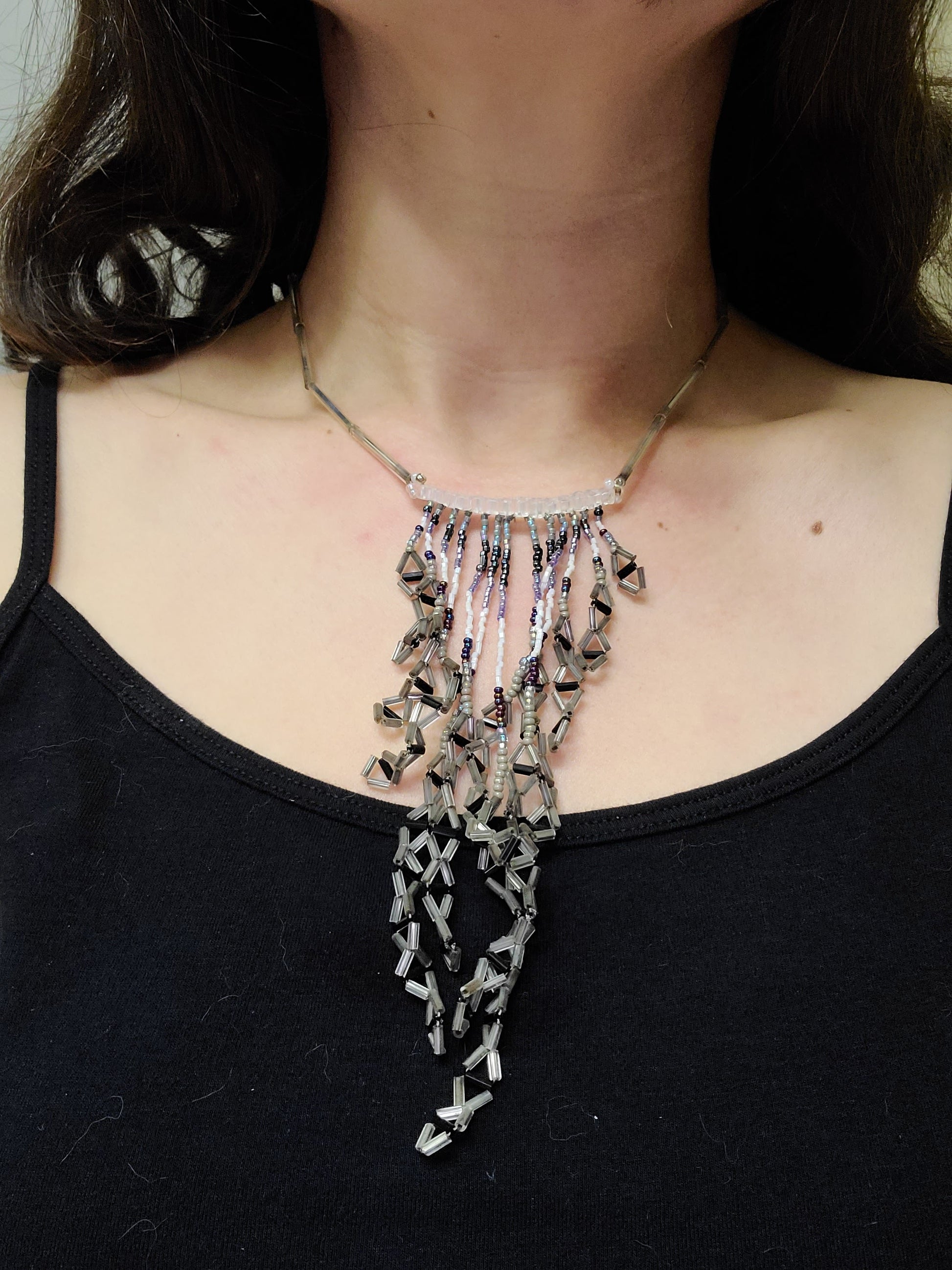 Woman wearing silver and iris fringe statement necklace.