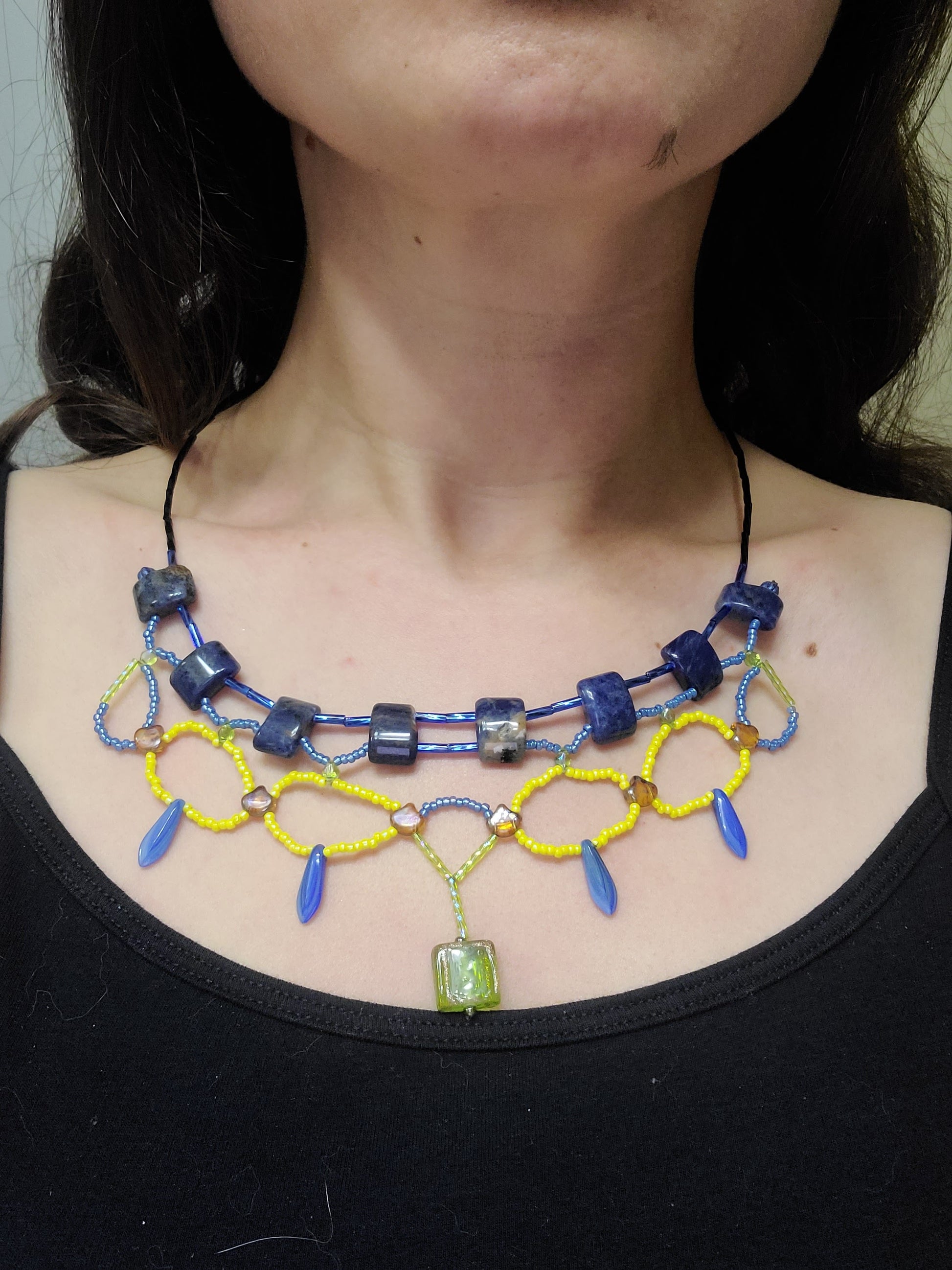 Woman wearing blue and yellow sodalite statement necklace.