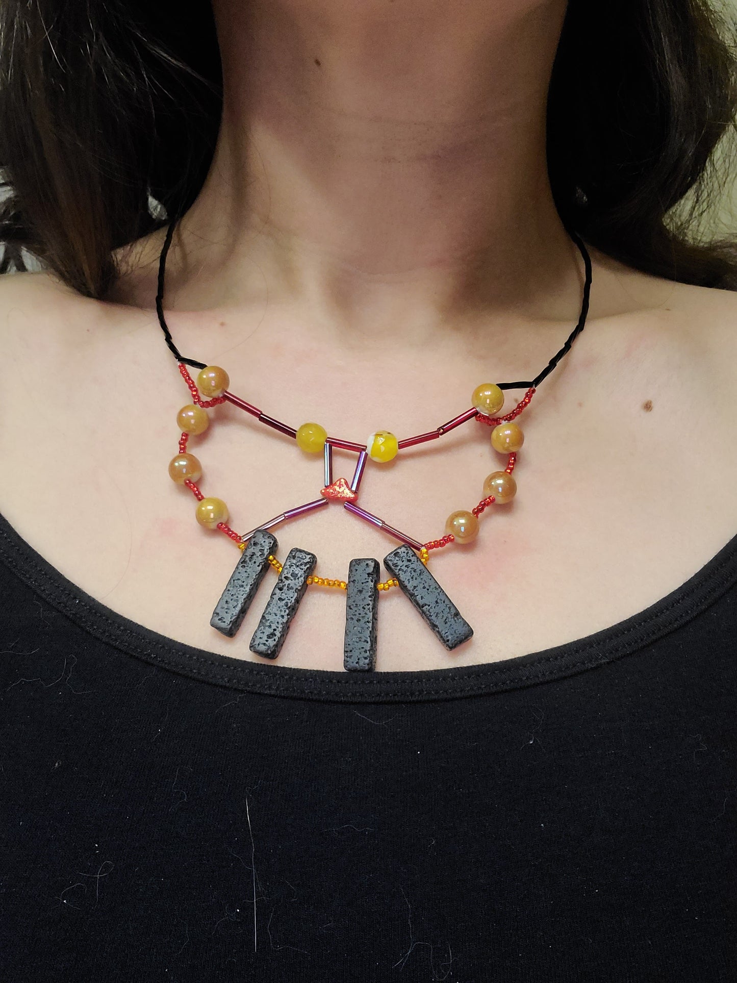 Woman wearing sunset butterfly necklace with lava beads.