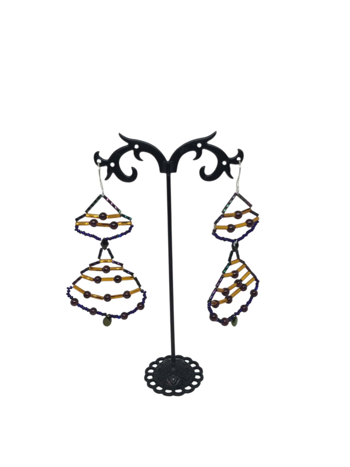 Stacked teardrop drop earrings with deep red pyrope garnet rounds, blue-violet iridescent frames, amber gold glass tubes, and pale glass teardrop drop.