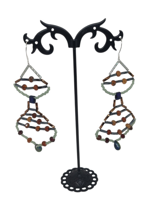 Stacked teardrop drop earrings with hessonite garnet rounds, sage green frame, dark blue glass center bead, and glass teardrop drop.
