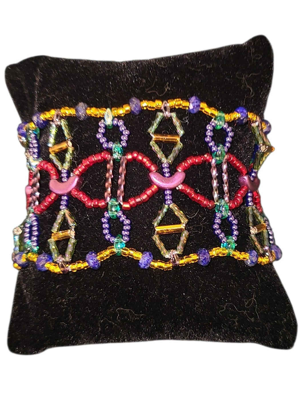 Wide lapis lazuli beaded bracelet with open geometric cell pattern in cobalt, red, and olive glass on a stretch cord