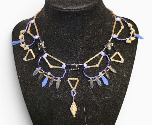 Snowflake obsidian geometric beaded statement necklace with gold brass tube framework and blue dagger drop fringe, front view
