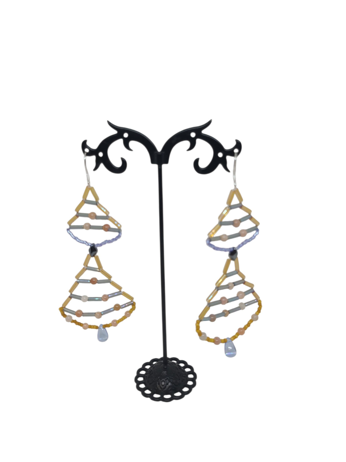 Stacked teardrop drop earrings with warm peachy-gold sunstone rounds, blue-violet iridescent frames, dark brown metallic diamond junction bead, and clear pale blue glass teardrop drop.