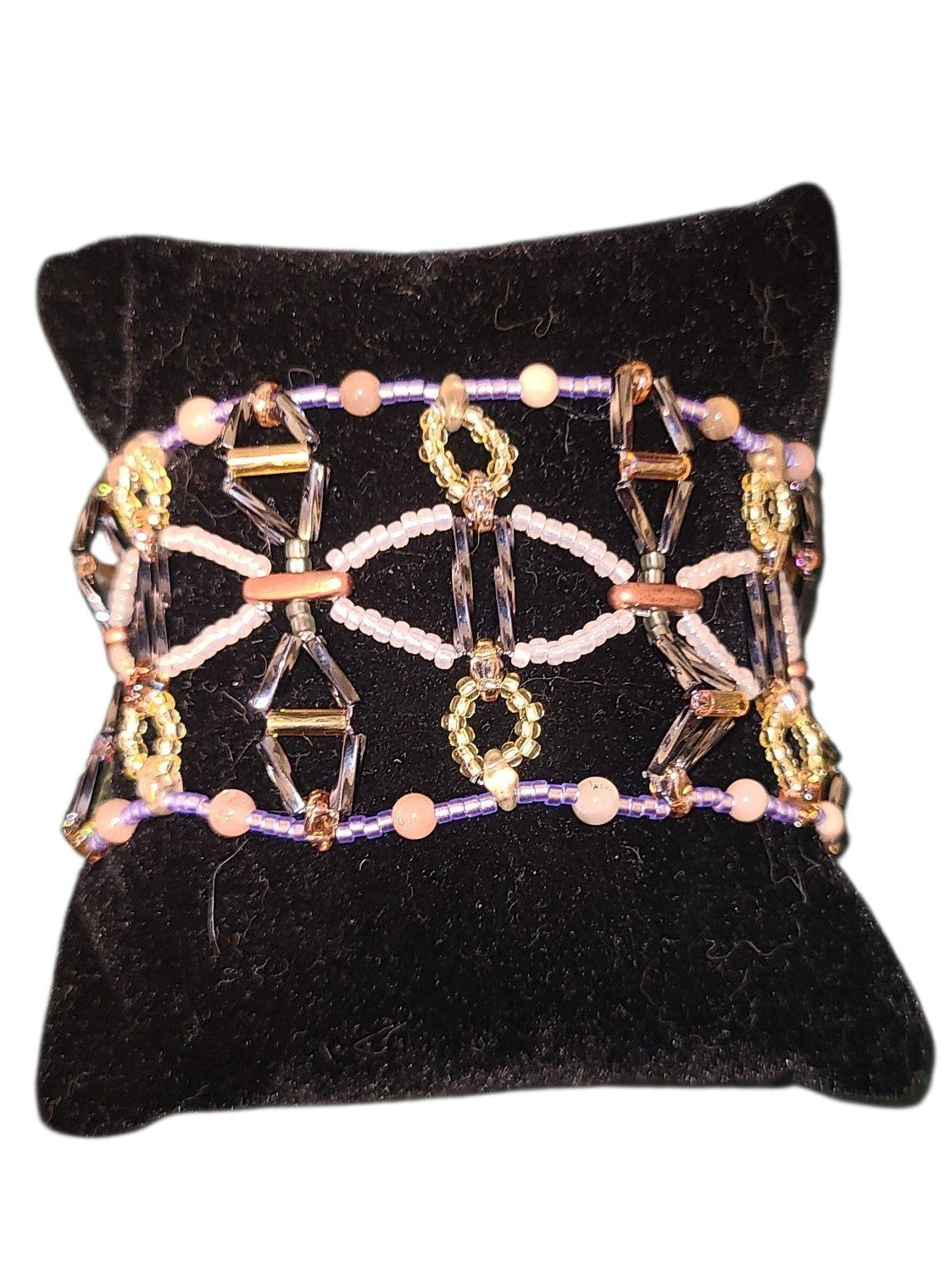 Wide Gothic lattice beaded cuff bracelet in gunmetal, copper, amber, and peach sunstone on a neutral background