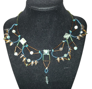 Tree agate geometric beaded necklace with teal and bronze curved framework and bronze dagger drop fringe, front view